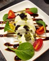 ein weißer Teller mit Essen mit Gemüse und Soße in der Unterkunft Lion Gate Hotel in Sarandë