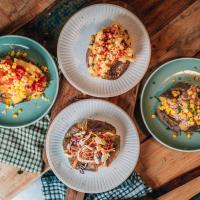 a group of plates of food on a wooden table at TradeStop Short-Term Accomodation in Raglan