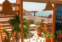 a balcony with a table and potted plants at Surf Break Morocco in Imsouane