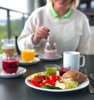 a woman sitting at a table with a plate of food at Kragerø Resort in Kragerø
