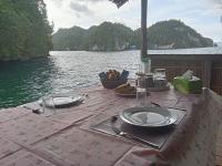 a table with plates and utensils on top of the water at Pin Wawiyai Natural Homestay in Yennanas Besir