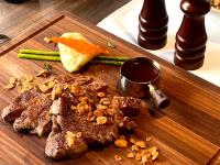 uma tábua de corte de madeira com carne e legumes em CP Hotel em Dayuan