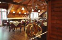 um restaurante com mesas e cadeiras numa sala com tectos em madeira em Appartaments Lavaredo em Carbonin