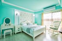 a blue bedroom with a bed and a chair at Ediman Bed &amp; Breakfast in Hualien City