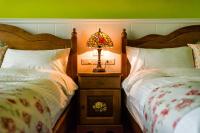 a bedroom with two beds and a lamp on a night stand at Ediman Bed &amp; Breakfast in Hualien City