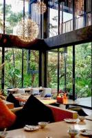 een restaurant met tafels en stoelen en grote ramen bij Natural Place in Ban Khan Ham