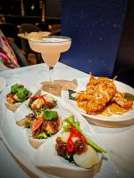 una mesa con platos de comida y una copa de vino en Mollymook Shores, en Mollymook