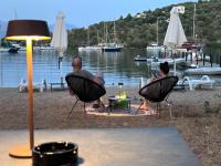 un par de personas sentadas en sillas junto al agua en Amphitheatro Boutique Hotel, en Meganisi