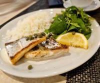 a plate of food with fish and rice and a salad at Hanza Hotel in Rīga