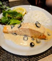 a plate of food with a piece of fish and rice at Hanza Hotel in Rīga