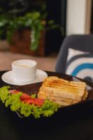 un sandwich sur une assiette noire avec de la laitue et de la tomate dans l'établissement ibis BH Afonso Pena Savassi, à Belo Horizonte