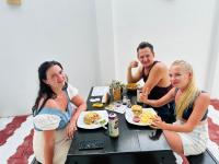 um grupo de pessoas sentadas à mesa comendo comida em iResort em Weligama