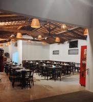 een eetkamer met tafels, stoelen en lampen bij Santa Areia Lençóis Pousada in Santo Amaro