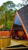 a house with a triangular window on a deck at Chalé Boutique Spa- Sauna seca, Jacuzzi , Rede suspensa in Campos do Jordão
