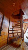 a wooden spiral staircase in a wooden cabin at Chalé Boutique Spa- Sauna seca, Jacuzzi , Rede suspensa in Campos do Jordão
