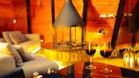 a living room with a table with two glasses of wine at Chalé Boutique Spa- Sauna seca, Jacuzzi , Rede suspensa in Campos do Jordão