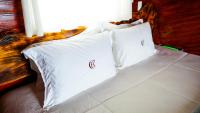 a bed with two white pillows on top of it at Chalé Boutique Spa- Sauna seca, Jacuzzi , Rede suspensa in Campos do Jordão