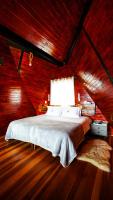 a bedroom with a bed in a wooden room at Chalé Boutique Spa- Sauna seca, Jacuzzi , Rede suspensa in Campos do Jordão
