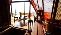 a porch with a table and a large window at Chalé Boutique Spa- Sauna seca, Jacuzzi , Rede suspensa in Campos do Jordão
