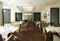 a dining room with white tables and chairs at Tandreas Hotel & Restaurant in Gießen