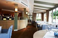 a restaurant with tables and chairs and a bar at Tandreas Hotel & Restaurant in Gießen