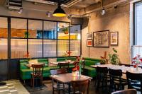 a restaurant with tables and chairs and a green couch at Amsterdam ID Aparthotel in Amsterdam