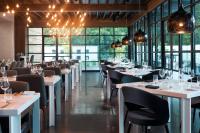 een restaurant met witte tafels, stoelen en ramen bij Le Meridien Atlanta Perimeter in Atlanta
