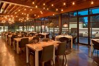 een eetkamer met tafels, stoelen en lampen bij Le Meridien Atlanta Perimeter in Atlanta