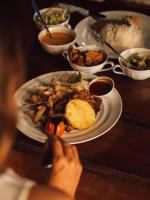 a table with plates of food and bowls of food at Sundaras Infinity Jungle Resort in Dambulla