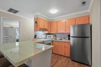 eine Küche mit orangefarbenen Schränken und einem Kühlschrank aus Edelstahl in der Unterkunft Domingos Beach Bungalow- Surfs Up in Myrtle Beach