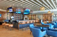 萨尼亚Four Points by Sheraton Point Edward Sarnia的餐厅内的酒吧配有蓝色的桌椅