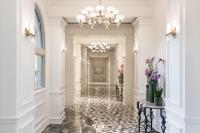 a hallway with white walls and a chandelier at The Ritz-Carlton, Sarasota in Sarasota