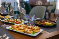 Una mesa con dos platos de comida y copas de vino. en Holiday Hotel, en Tirana