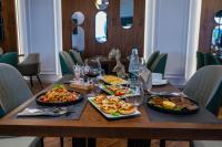 una mesa con platos de comida y copas de vino en Holiday Hotel, en Tirana