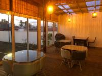 a room with two tables and chairs and windows at Lindsey Hôtel in Saint-Pierre