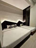 two beds in a hotel room with white sheets at Airlangga Hotel in Yogyakarta