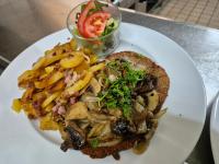 a plate of food with a sandwich and french fries at Hotel am Schlosspark in Bad Bentheim