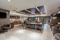 um restaurante com mesas, cadeiras e um bar em SpringHill Suites by Marriott Austin The Domain Area em Austin