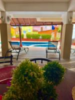 シワタネホにあるHotel Zihuatanejo Centroの椅子2脚と植物テーブル1台が備わる部屋