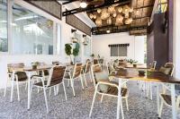 una sala da pranzo con tavoli e sedie in legno di Moringa Tree Maison a Siem Reap