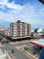 un gran edificio de apartamentos en una ciudad con aparcamiento en Grand Hotel Americano, en Machala