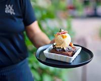 una persona sosteniendo un plato con un postre en él en Appellation Lodi - Wine & Roses Resort and Spa, en Lodi