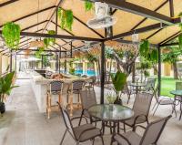 een terras met tafels en stoelen en een bar bij Mermaid Beach Resort in Jomtien Beach