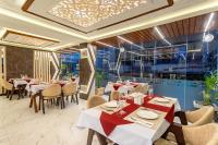 a restaurant with tables and chairs and a ceiling at Airport Diana Hotel in Kathmandu