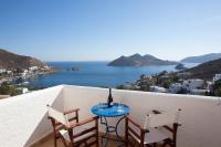 Una mesa y sillas en un balcón con vista al mar. en Golden Sun Hotel Patmos, en Patmos