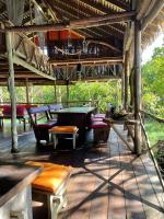 Un porche con bancos y una mesa de billar. en Urraca Monkey Island Eco Resort, en Buena Vista