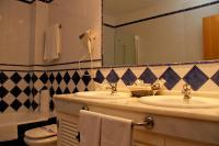 a bathroom with two sinks and a mirror at Hotel Tugasa Castillo de Castellar in Castellar de la Frontera