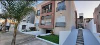 un edificio de apartamentos con escaleras y una palmera en Punto Termal - Depto 8, en Federación