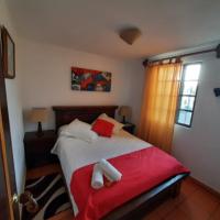 Un dormitorio con una cama con almohadas rojas y blancas. en Aparta Hotel El Refugio de María, en Villa de Leyva