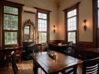 Un restaurante con mesas y sillas de madera y ventanas. en Tabist Kaihorow Otaru, en Otaru